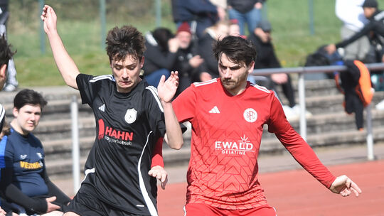 Der Bad Sobernheimer Axel Neumann (rotes Trikot) stellt einem Gegenspieler von der SG Gräfenbachtal ein Bein, die Gäste nehmen a Der Bad Sobernheimer Axel Neumann (rotes Trikot) stellt einem Gegenspieler von der SG Gräfenbachtal ein Bein, die Gäste nehmen a