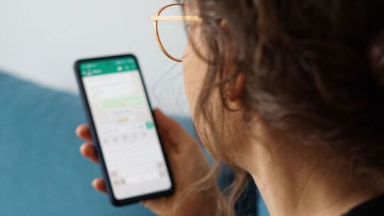 Eine junge Frau liest eine Nachricht auf einem Smartphone Eine junge Frau liest eine Nachricht auf einem Smartphone