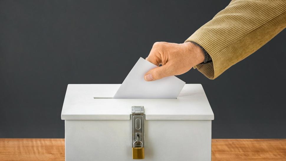Mann wirft Stimmzettel in Wahlurne 