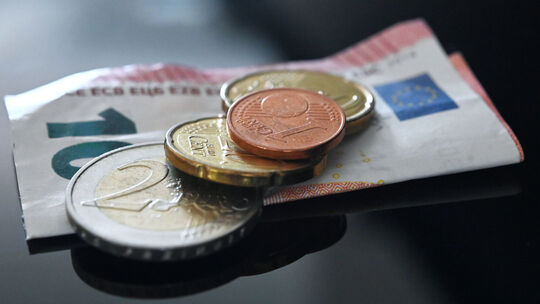 ARCHIV - 26.06.2023, Baden-Württemberg, Stuttgart: ILLUSTRATION - Münzen und ein Geldschein im Wert von 12,41 Euro liegen auf ei Mindestlohn