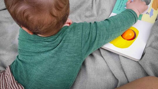 Ein sieben Monate altes Baby spielt auf einer Decke Ein sieben Monate altes Baby spielt auf einer Decke