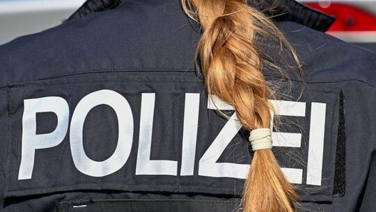 Der Zopf einer Polizistin hängt über ihre Uniform. Der Zopf einer Polizistin hängt über ihre Uniform.