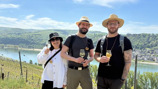 Der Mittelrheinische Weinfrühling lockt Besucher aus nah und fern in den Bopparder Hamm. Diese drei Wanderer genießen Wein, Sonn Der Mittelrheinische Weinfrühling lockt Besucher aus nah und fern in den Bopparder Hamm. Diese drei Wanderer genießen Wein, Sonn