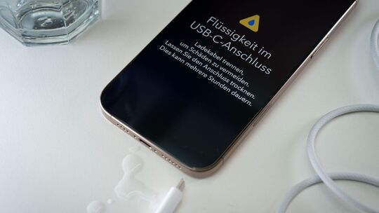 Ein iPhone mit einer Flüssigkeitswarnung und Wassertropfen Ein iPhone mit einer Flüssigkeitswarnung und Wassertropfen