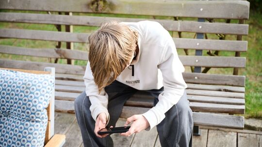Ein Junge guckt auf sein Smartphone Ein Junge guckt auf sein Smartphone