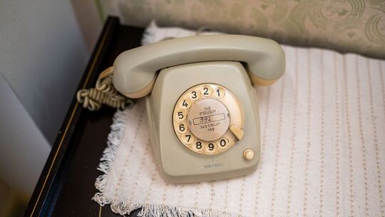 Ein Wählscheibentelefon steht auf einem Tisch Ein Wählscheibentelefon steht auf einem Tisch