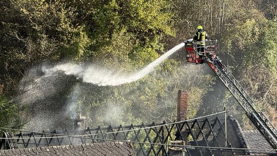 Unter anderem mithilfe einer Drehleiter löscht die Feuerwehr die Flammen in Zell-Merl. Von dem Dachstuhl ist das Gerippe übrig g Unter anderem mithilfe einer Drehleiter löscht die Feuerwehr die Flammen in Zell-Merl. Von dem Dachstuhl ist das Gerippe übrig g