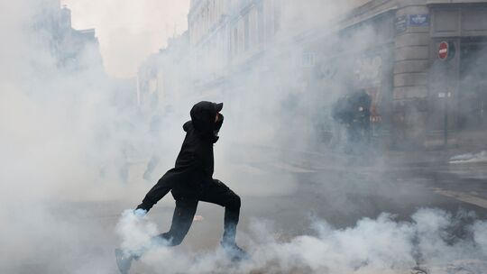Ein Demonstrant wirft laut der Deutschen-Presse-Agentur nach einer Demonstration in Rennes, Frankreich, eine Tränengasgranate in Ein Demonstrant wirft laut der Deutschen-Presse-Agentur nach einer Demonstration in Rennes, Frankreich, eine Tränengasgranate in