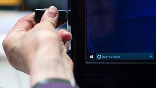 Eine Person zieht einen USB-Stick vom PC ab Eine Person zieht einen USB-Stick vom PC ab